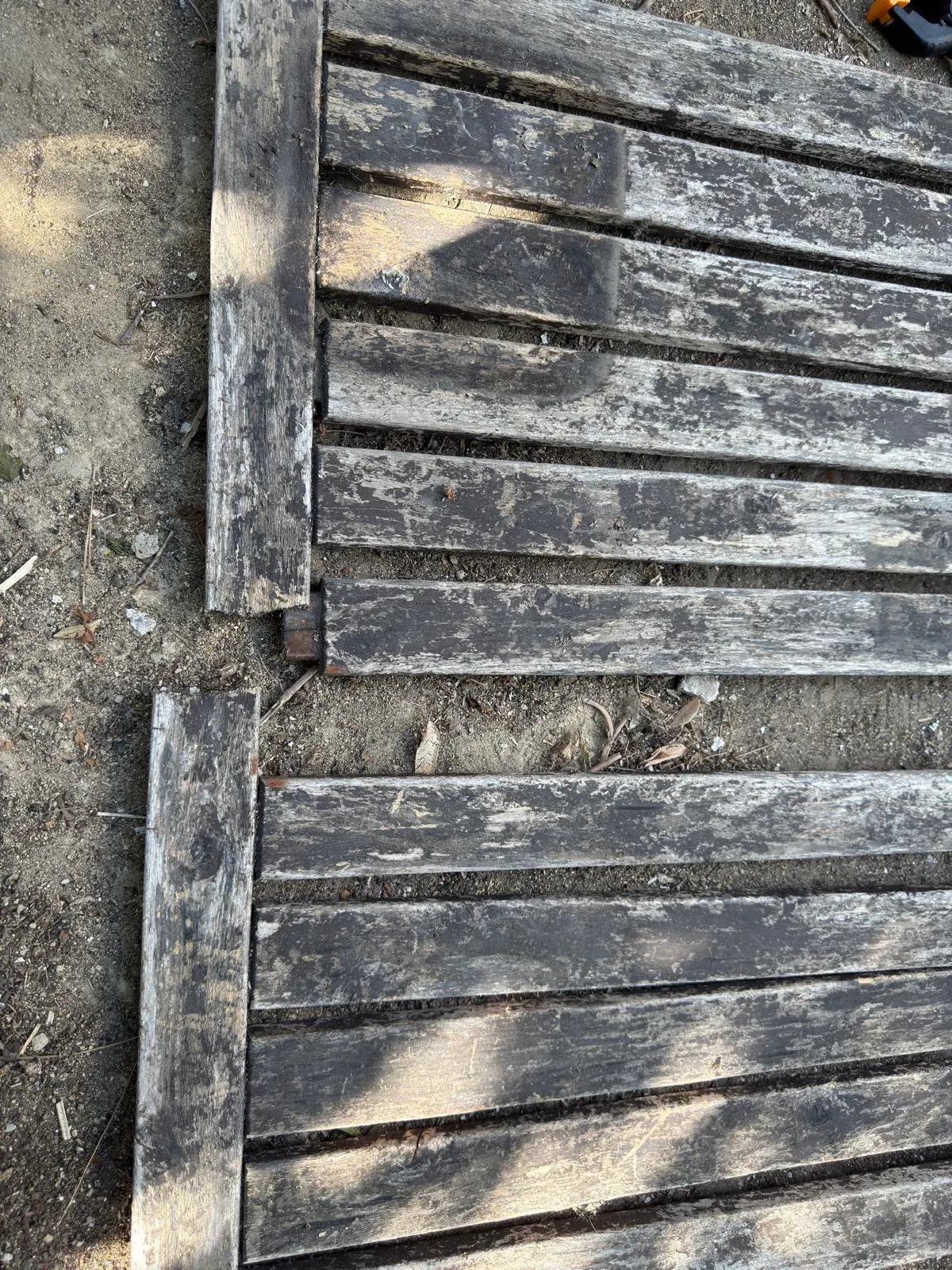 Söküm sırasında iki bölüme ayrılan hava koşullarından zarar görmüş bahçe masası çerçevesi