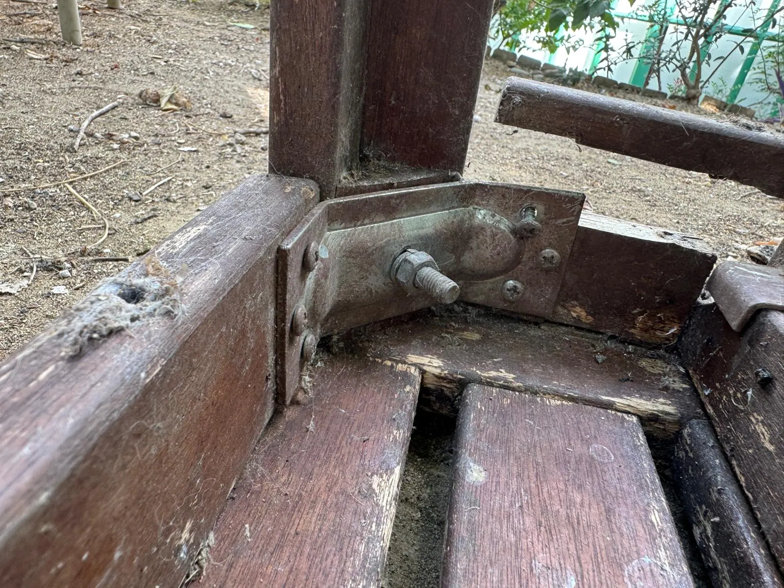Çatlamış ahşap masa kuşağının yanında ayağı bağlayan metal köşe braketi