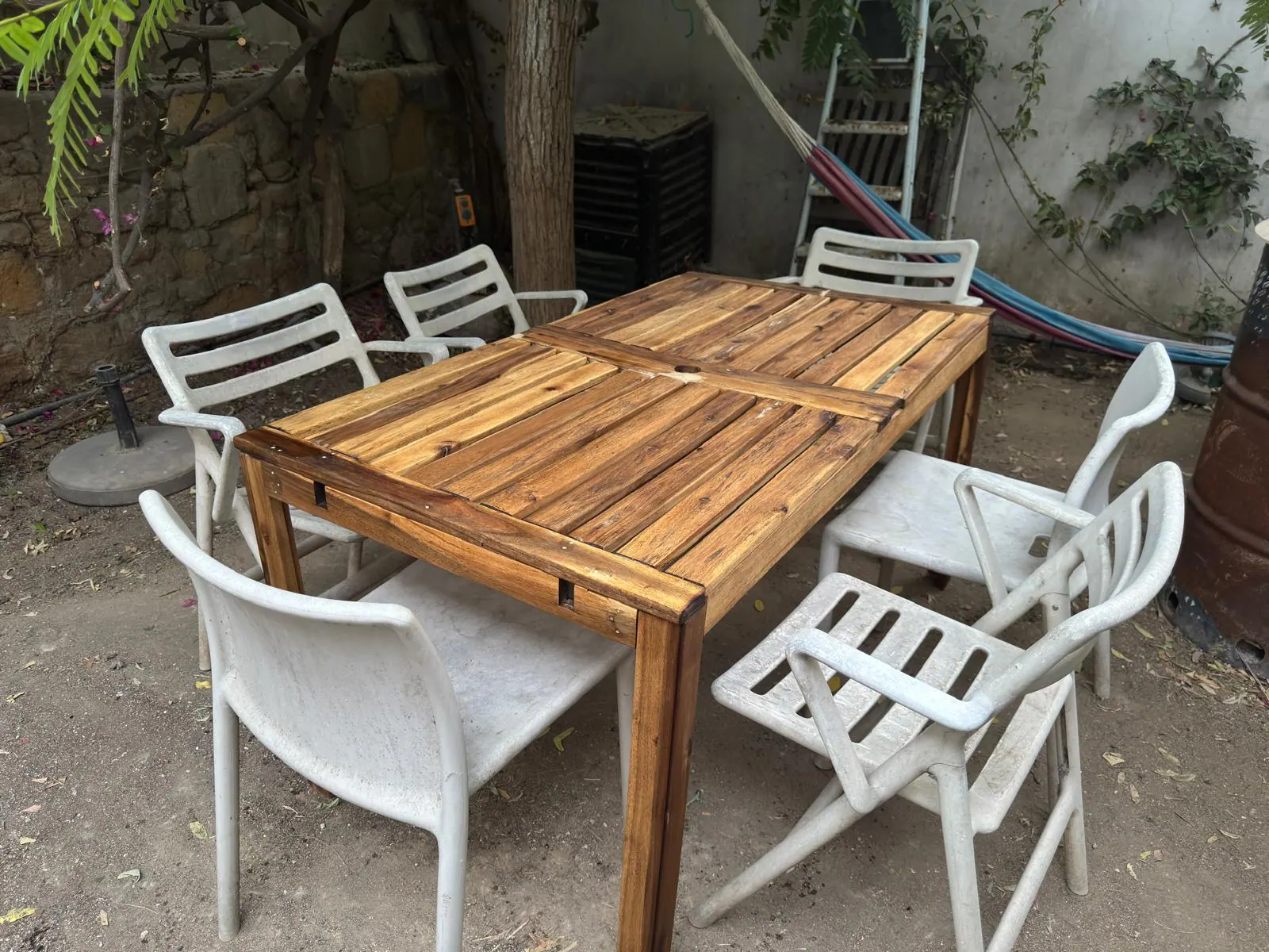 Kıbrıs'ta yapısal onarım ve iki kat tik yağı uygulamasından sonraki restore edilmiş ahşap bahçe masası