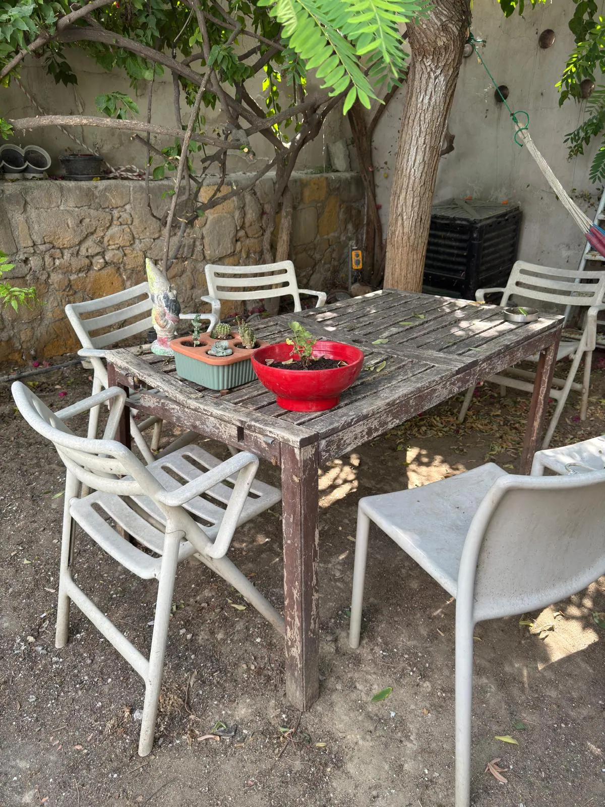 Kıbrıs'ta restorasyon öncesinde kaplaması dökülmüş, gri çıtalı ve sallanan ahşap bahçe masası
